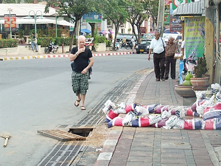 The offending hole without its drainage cover poses a hazard to pedestrians and motorists alike.